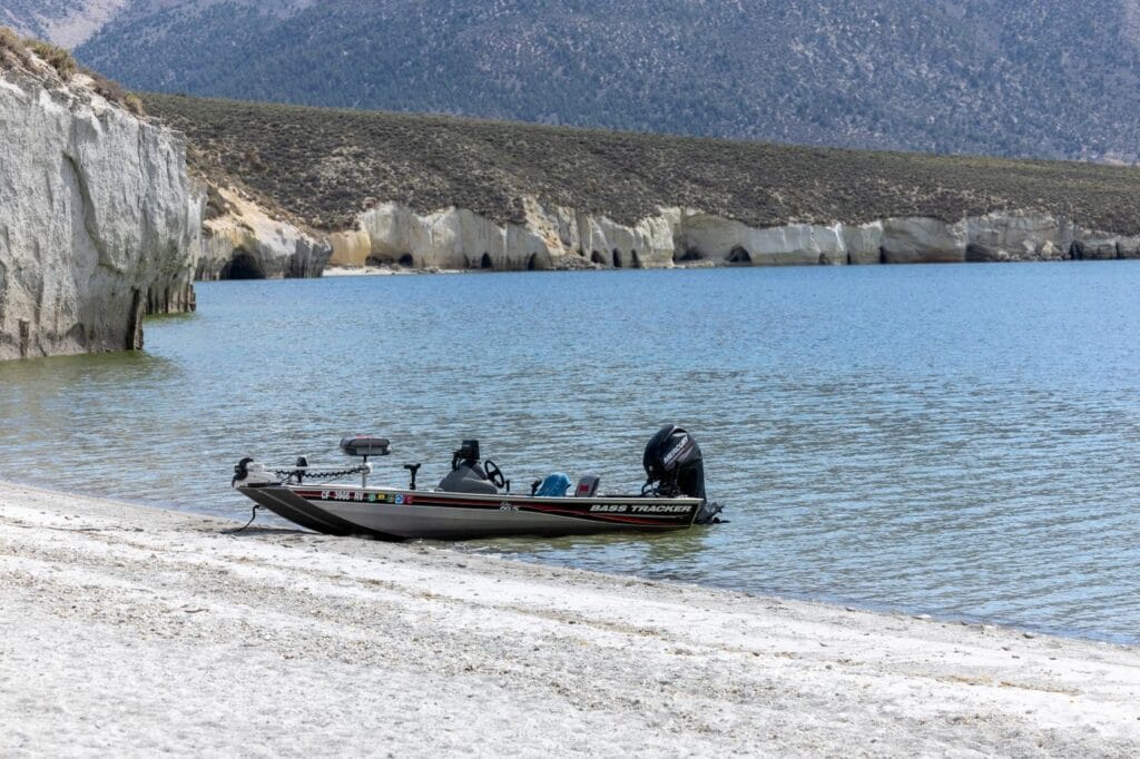 Boat fishing near a rocky lake bank