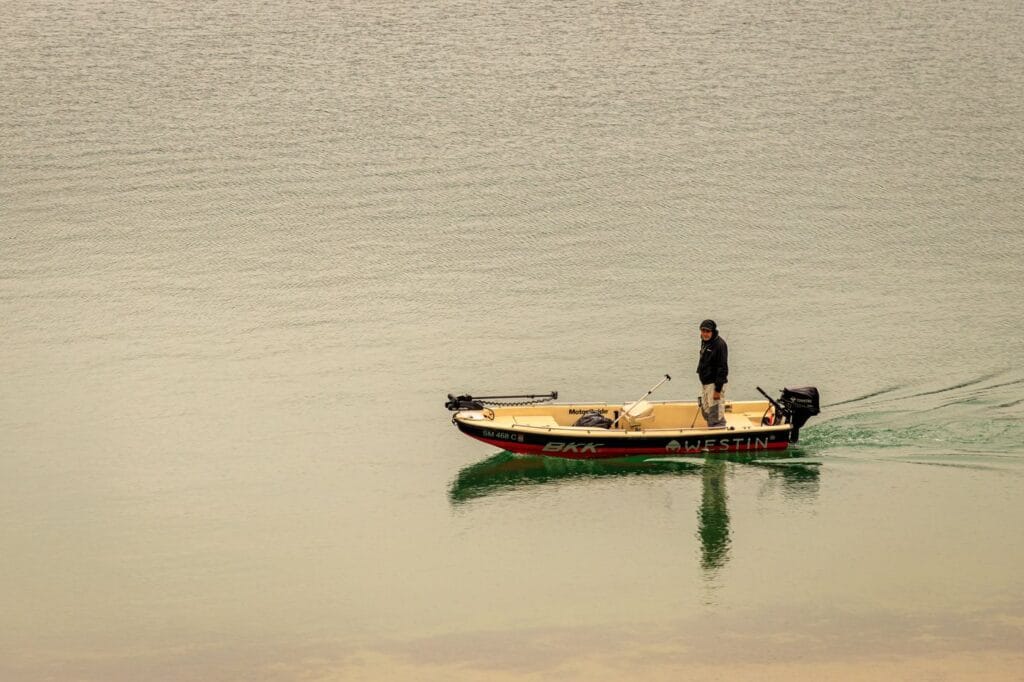 Angler fishing a calm summer lake